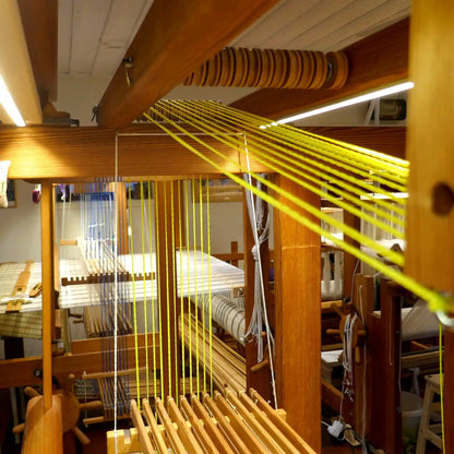 Gelbe Texsolv Schlaufenschnüre verlaufen über den Oberschaft eines hölzernen Webstuhls – gespannte U-Cord-Verbindung